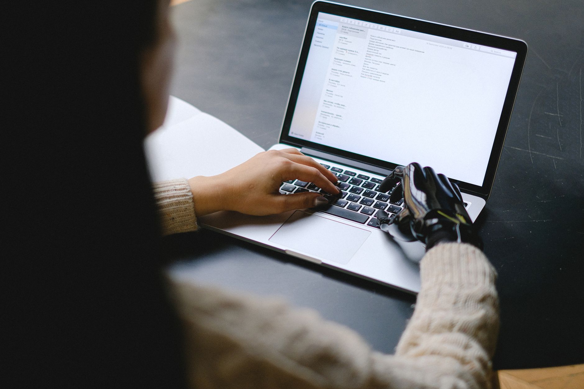 Person typing on a laptop while an AI chat assistant window is open
